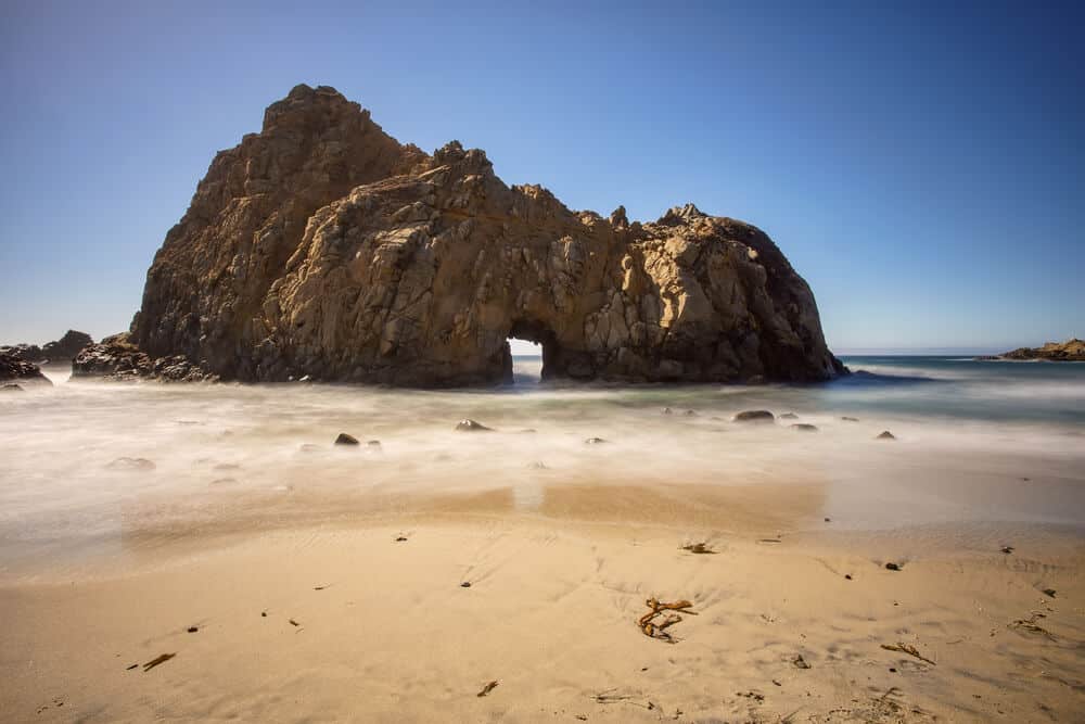 keyhole-shaped rock formation on the beach in big sur