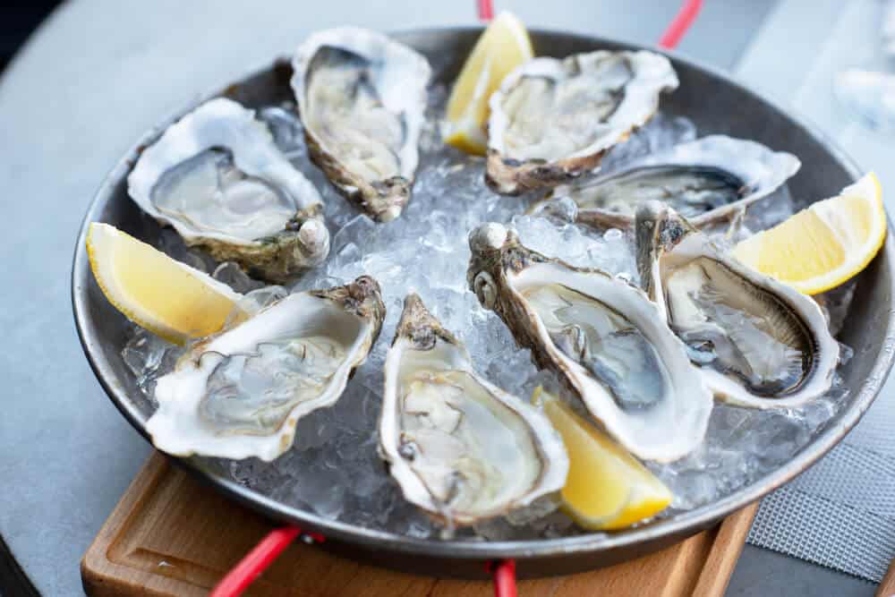 A plate of eight oysters served with lemon