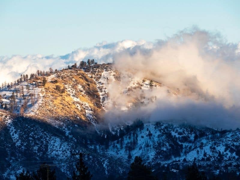 wrightwood mountains near los angeles covered in snow and mist and sunlight