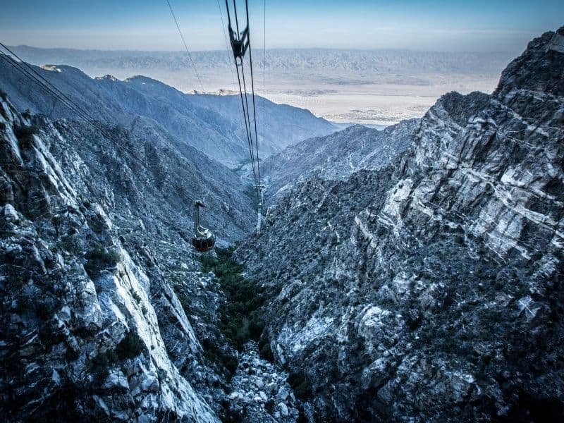 aerial tramway in palm springs with snow covering sides of the canyon as you go up to mt san jacinto