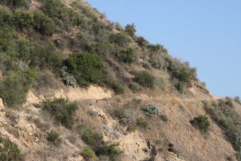 a trail in the side of the mountain on a sunny day