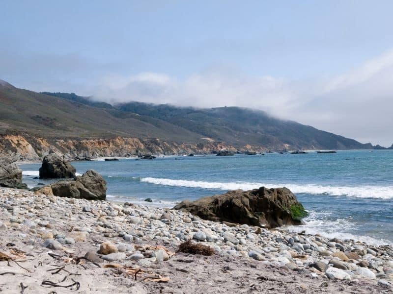 the shoreline at andrew molera beach with rocks at low tide so you can hike it