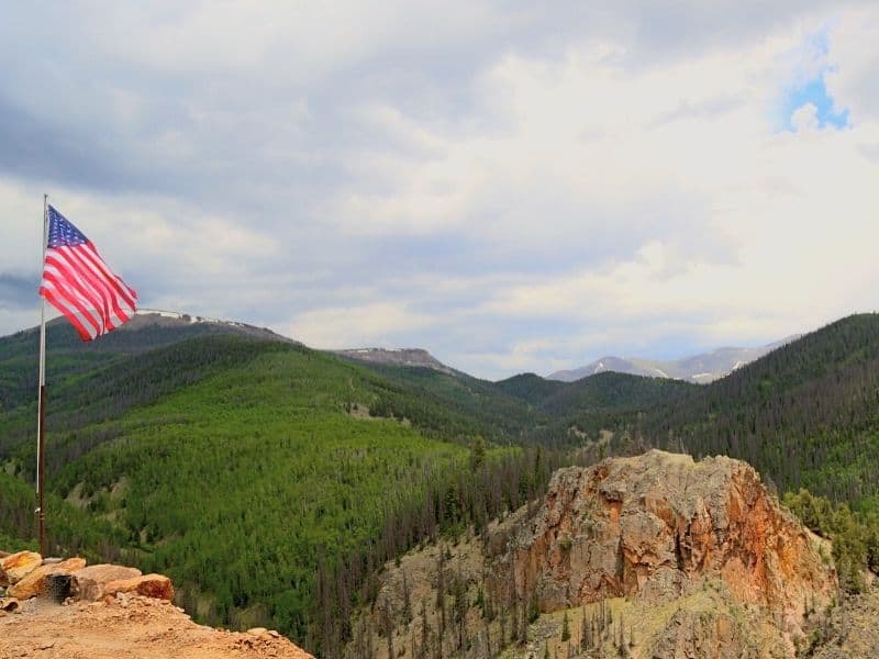 forested area around an old mine in northern california and an american flag