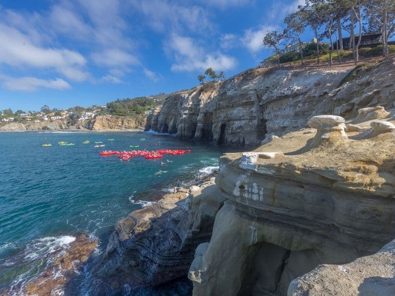 the area of la jolla sea caves with some groups of kayakers out and enjoying their day on the water