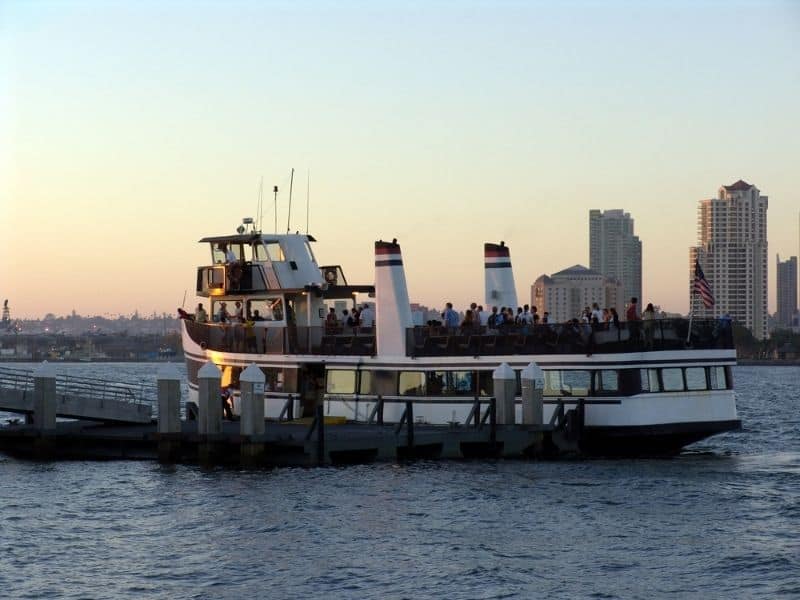 A boat of people boarding a harbor cruise boat in San Diego