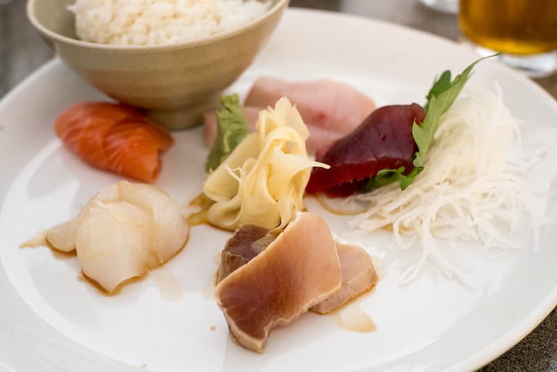 slices of fish with soy sauce and rice at a harborside restaurant on a weekend in long beach