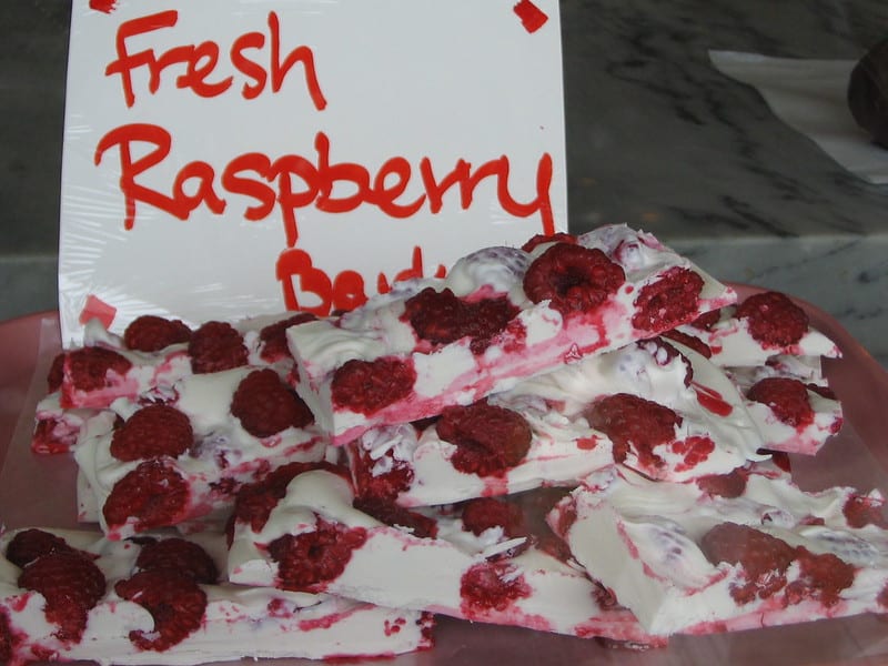 white chocolate with fresh raspberries with a sign that reads 'fresh raspberry bark'