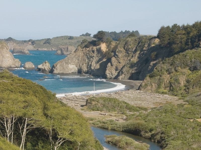 view from above big river beach in Mendocino with turquoise water and rock formations out at sea