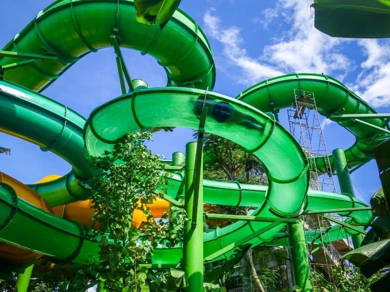 view of a person going down a waterslide as seen from below looking up, a green waterslide with a human body shadow