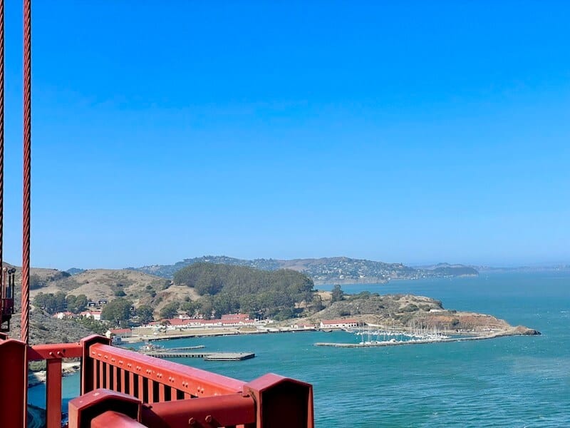 fort baker fortifications below the golden gate bridge with view of the railing in the foreground on a sunny day in san francisco