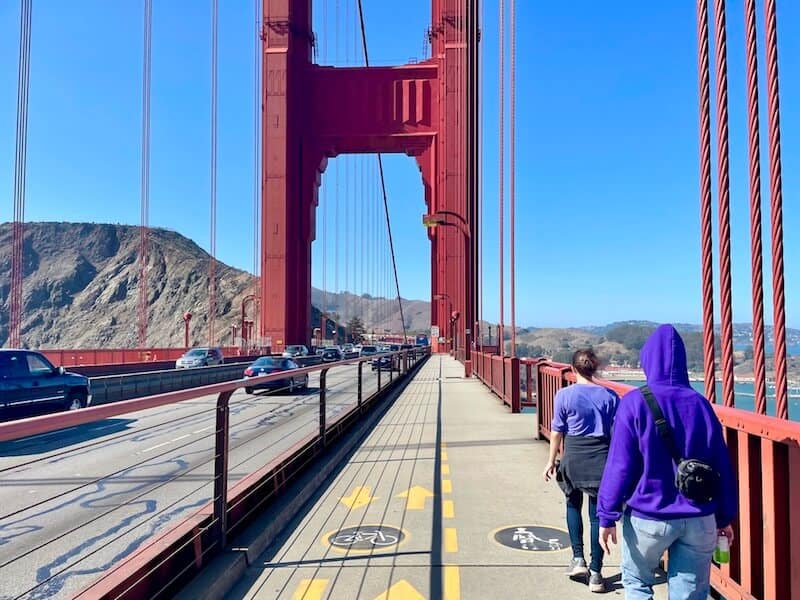 friends walking on the golden gate bridge wearing layers in the san francisco weather