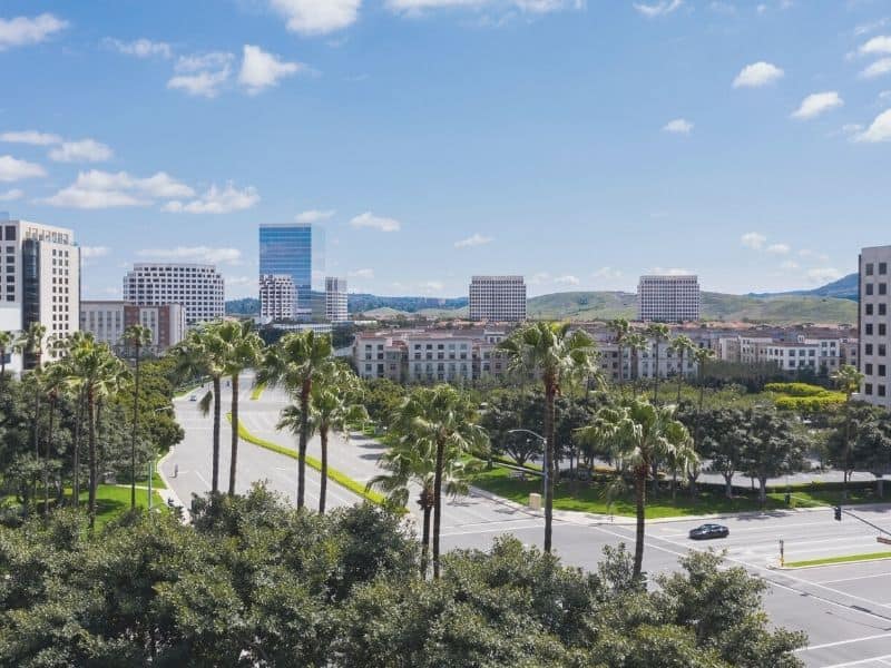 the downtown streets of irvine california with a blue sky and palm trees on the side of the street