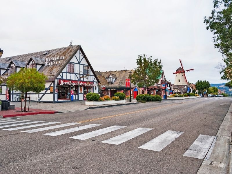 a crosswalk in the charming danish-style village of solvang california with its famous windmill visible down the street