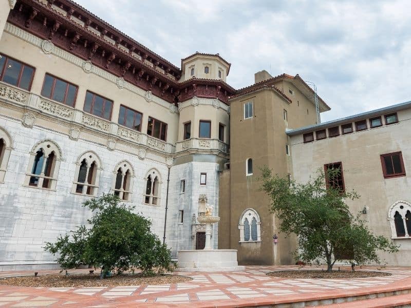 the courtyard of hearst castle with two trees, tile, and lots of impressive architecture