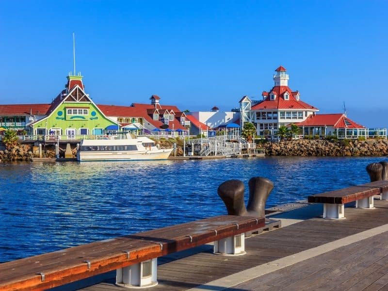 view of the lighthouse and other iconic buildings from the rainbow harbor area of long beach california