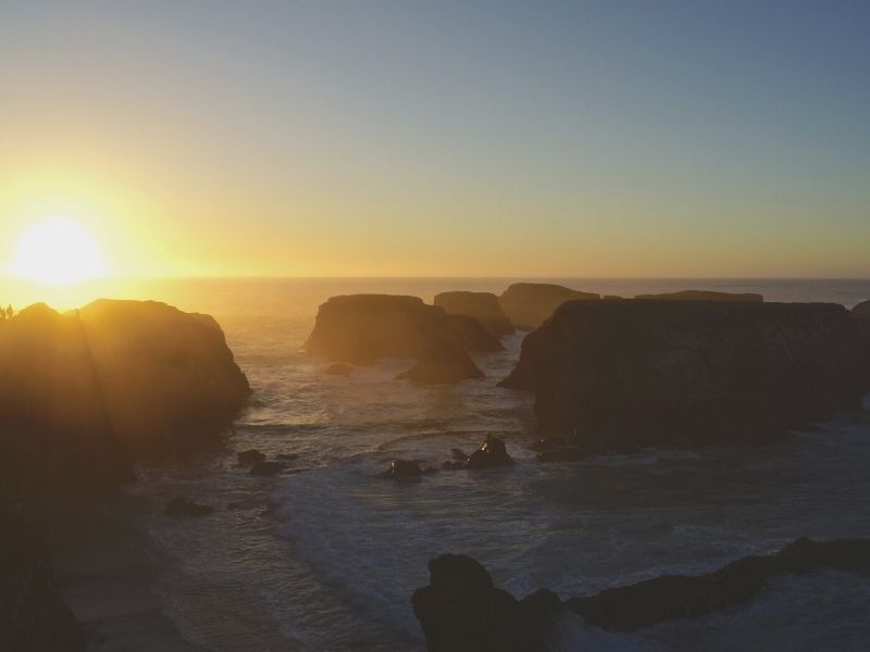 watching the sun set over the rock formations of Mendocino beach