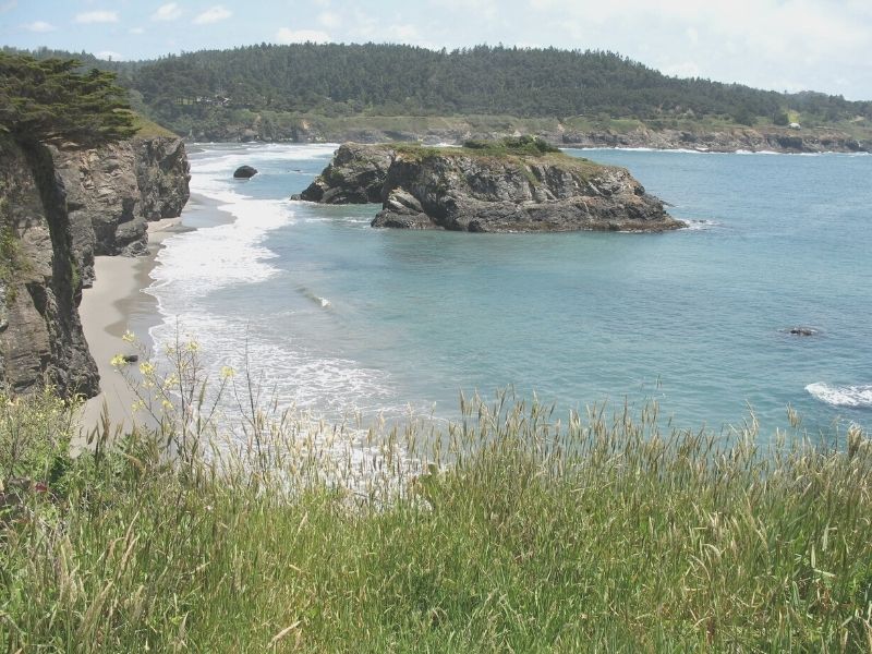 walking on the grassy hills in mendocino headlands state park above the rocky outcroppings in the ocean below