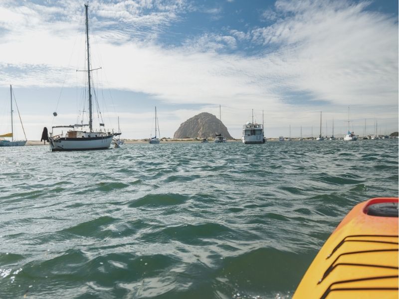 orange kayak out in morro bay heading towards the rock