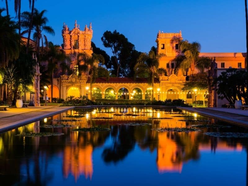 balboa park pond lit up at night in bright colors with dark blue sky