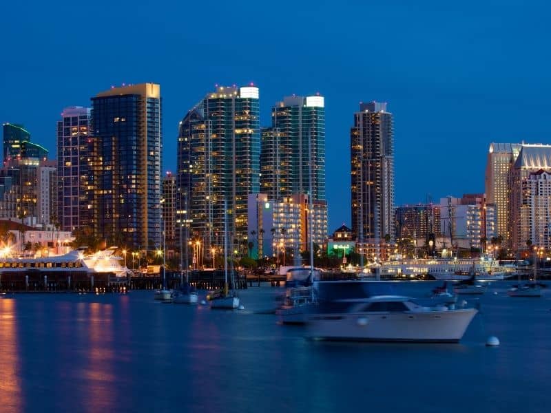 view of san Diego at night with skyscrapers and boats