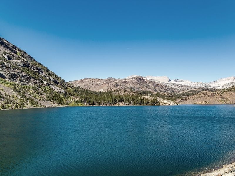 flat, turquoise water at ellery lake in tioga pass on the road over the mountains