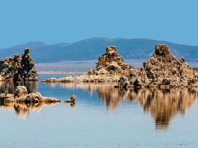 tufa rock formations of mono lake reflected in the water