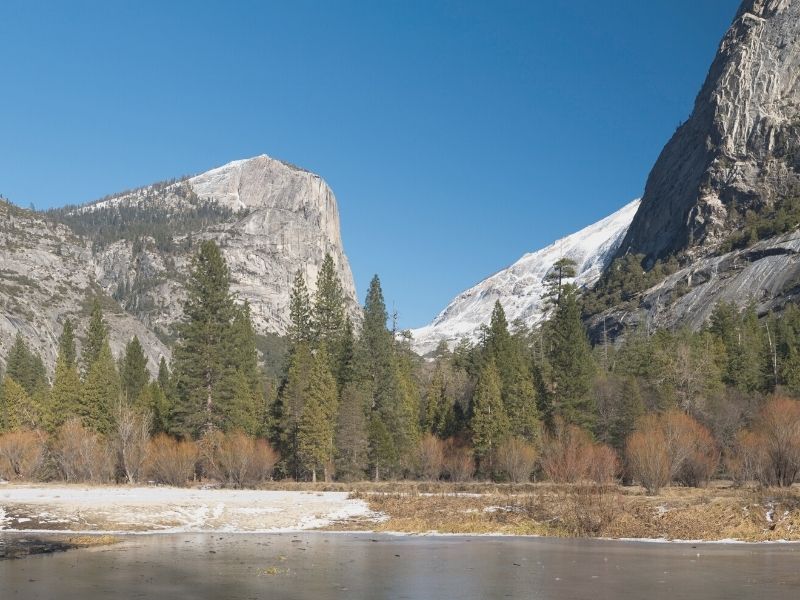 the frosted-over waters of mirror lake with half dome in the background