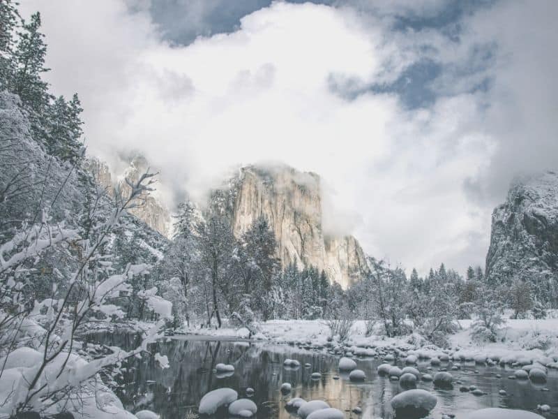 hiking in the snow in yosemite near creeks with snow and mountains nearby