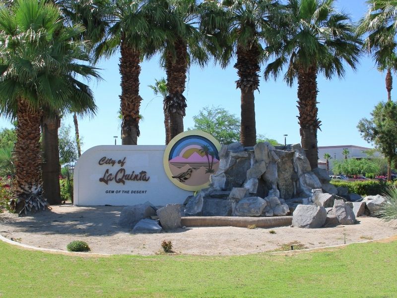 sign for entering la quinta california at the entrance to the town near palm trees 
