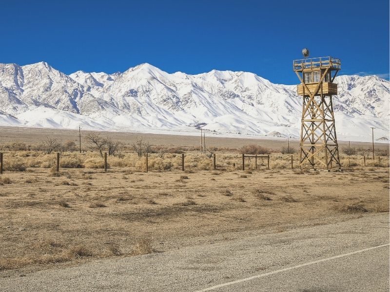 watch tower from the internment camp at Manzanar with mountains behind it