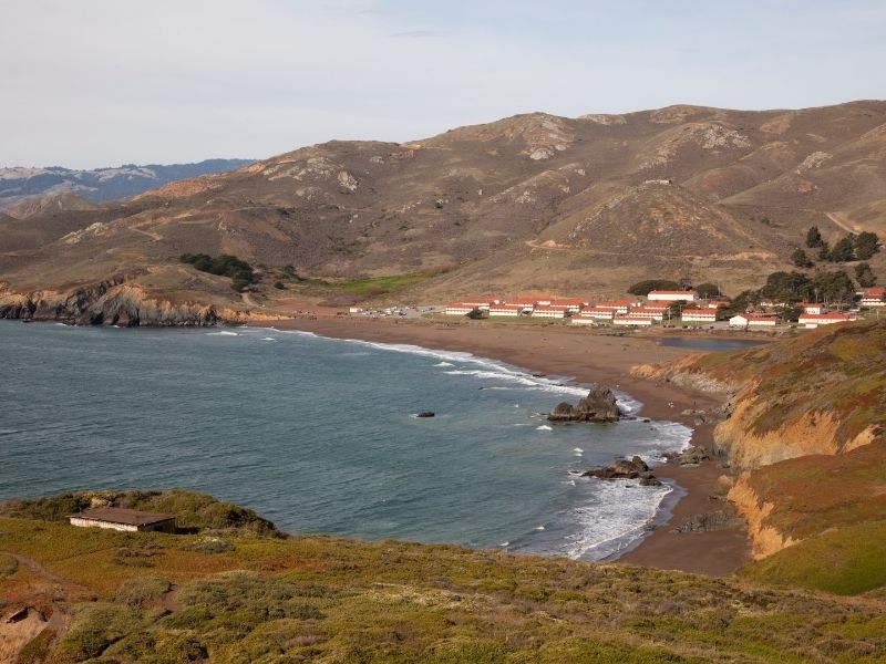 the pebble beach at rodeo beach with military barracks in the distance
