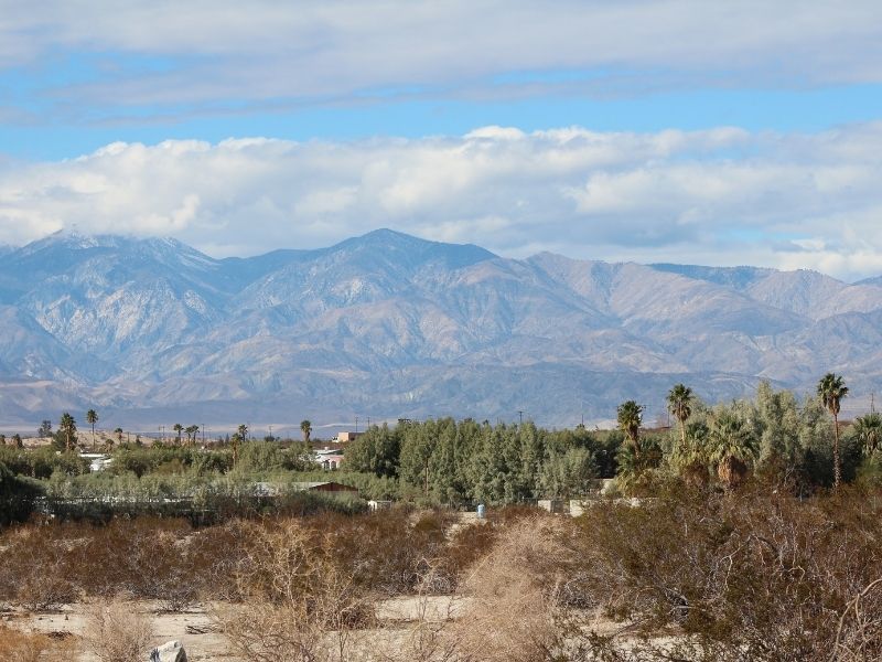 a view of the town of palm desert California with mountains in the distance