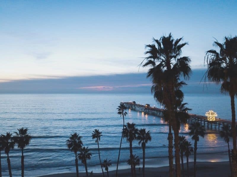 san clemente pier at night shortly after sunset at blue hour with palm trees and blue water