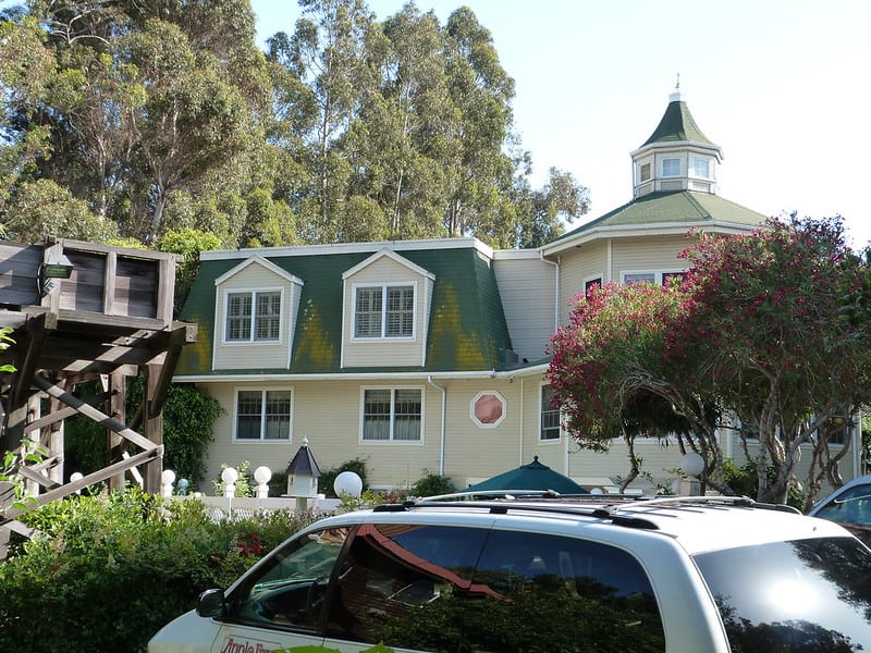 an old fashioned house with a car in front of it