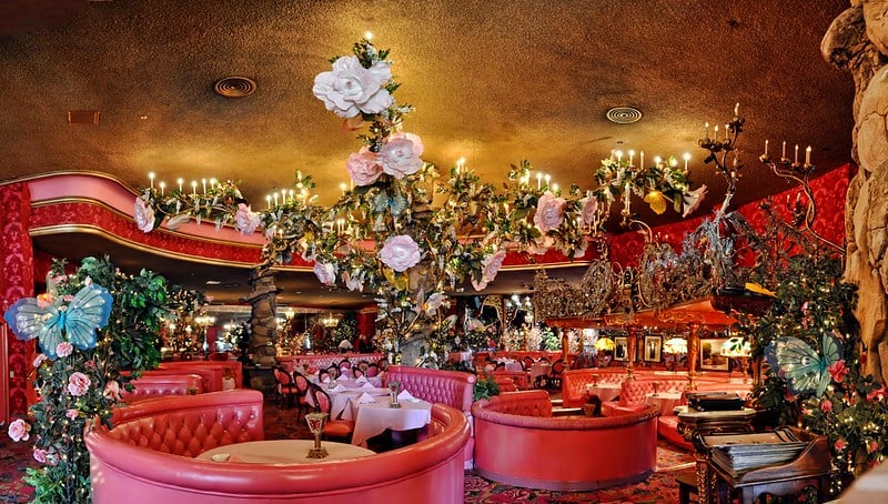 a brilliant pink restaurant with round booths and lots of flowers