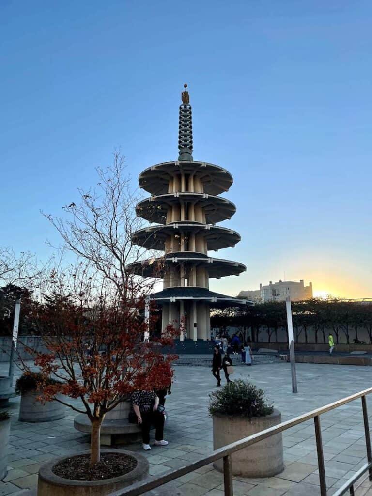 Sunset in Japantown with the five-tiered Peace Pagoda and a few people walking around in the city