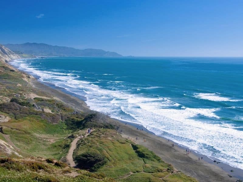 waves crashing on the beach on a sunny day at fort funston california