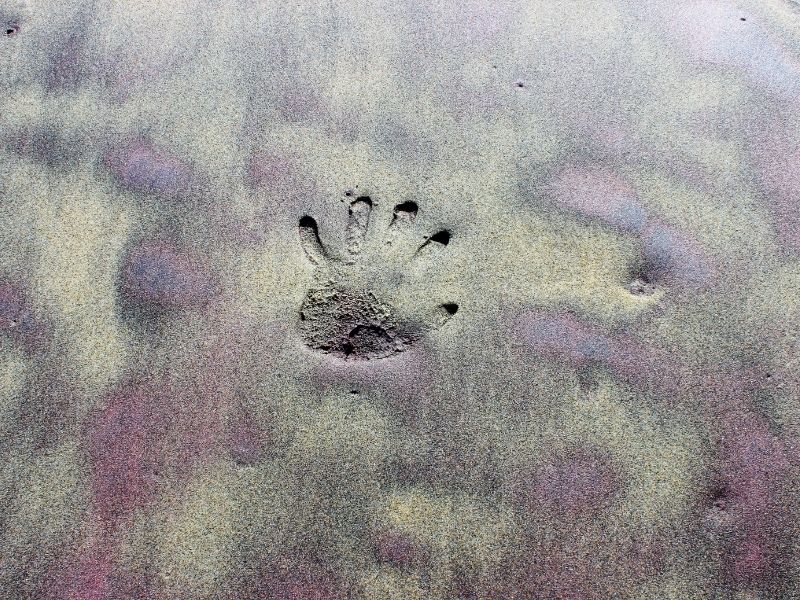 handprint in the purple sand at pfeiffer beach in big sur california