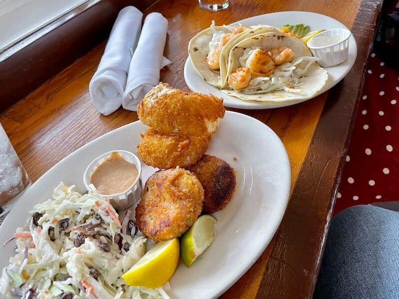 crab cakes with onion rings and coleslaw and shrimp taco plate