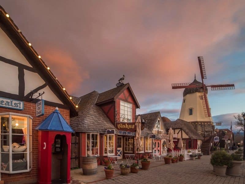 sunset in Solvang California along the Main Street with half timbered houses and a windmill in the distance