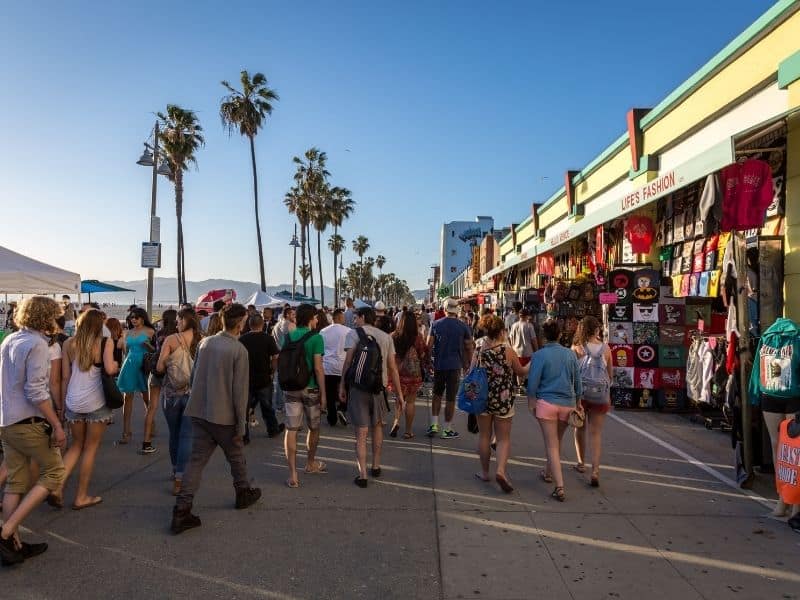 people walking in venice beach california on the boardwalk