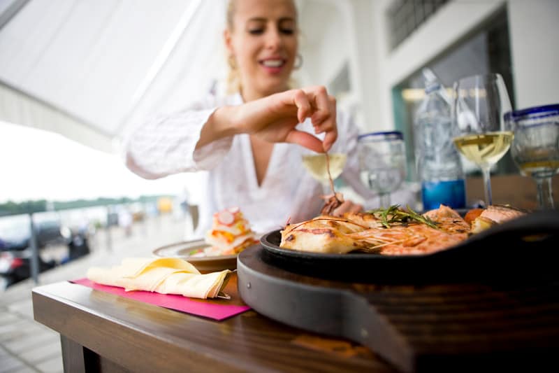 Woman eating fresh seafood with a glass of white wine