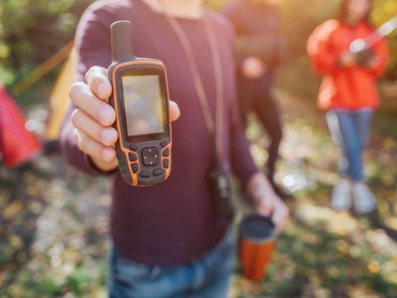 man holding a satellite phone wearing a long sleeve shirt