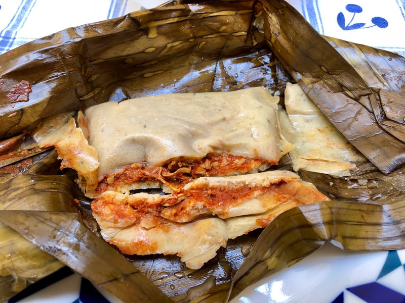 Tamales with chicken hot sauce and covered with banana leafs