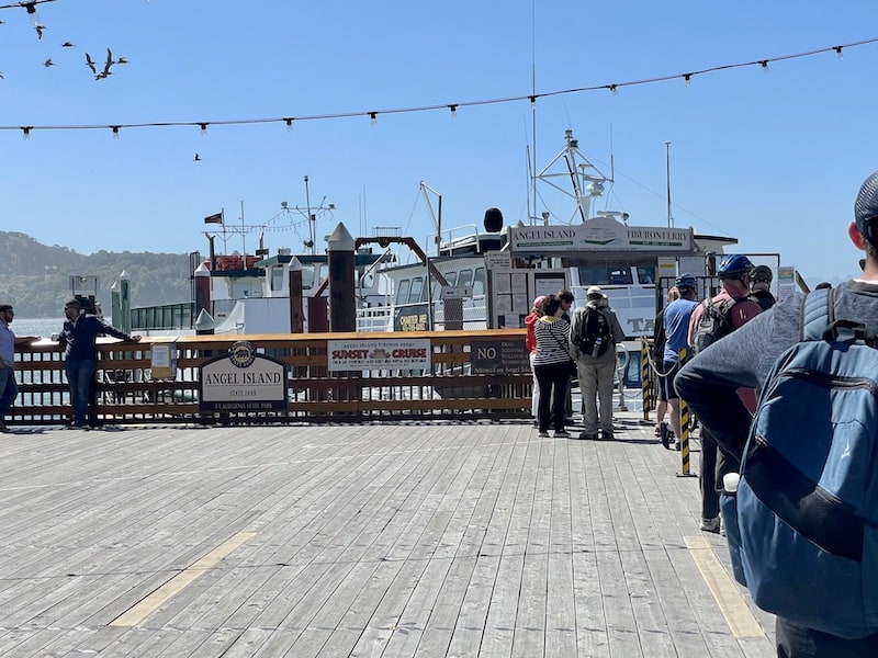 people standing in line waiting for the tiburon to angel island ferry